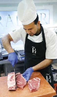 Carnicero cortando una pieza de vacuno