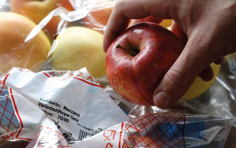 Mano cogiendo una manzana de una bolsa